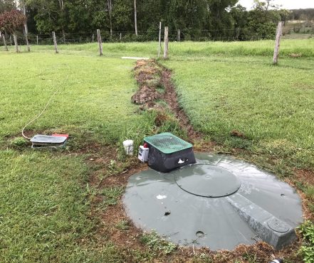 The homeowners had been forced to dig a trench to prevent untreated wastewater from entering their backyard.