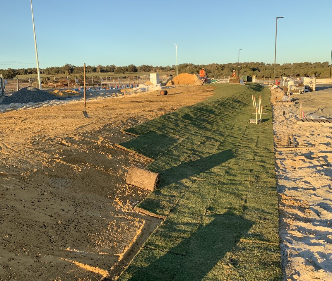 The turf is rolled out over the effluent disposal area which is now only visible as a grassy mound.
