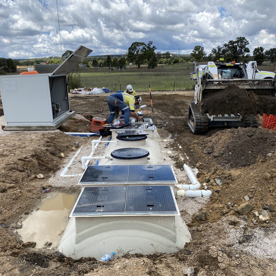 True Water site technicians complete the connections to the new treatment system and pump controller before transferring the wastewater flow from the old system.