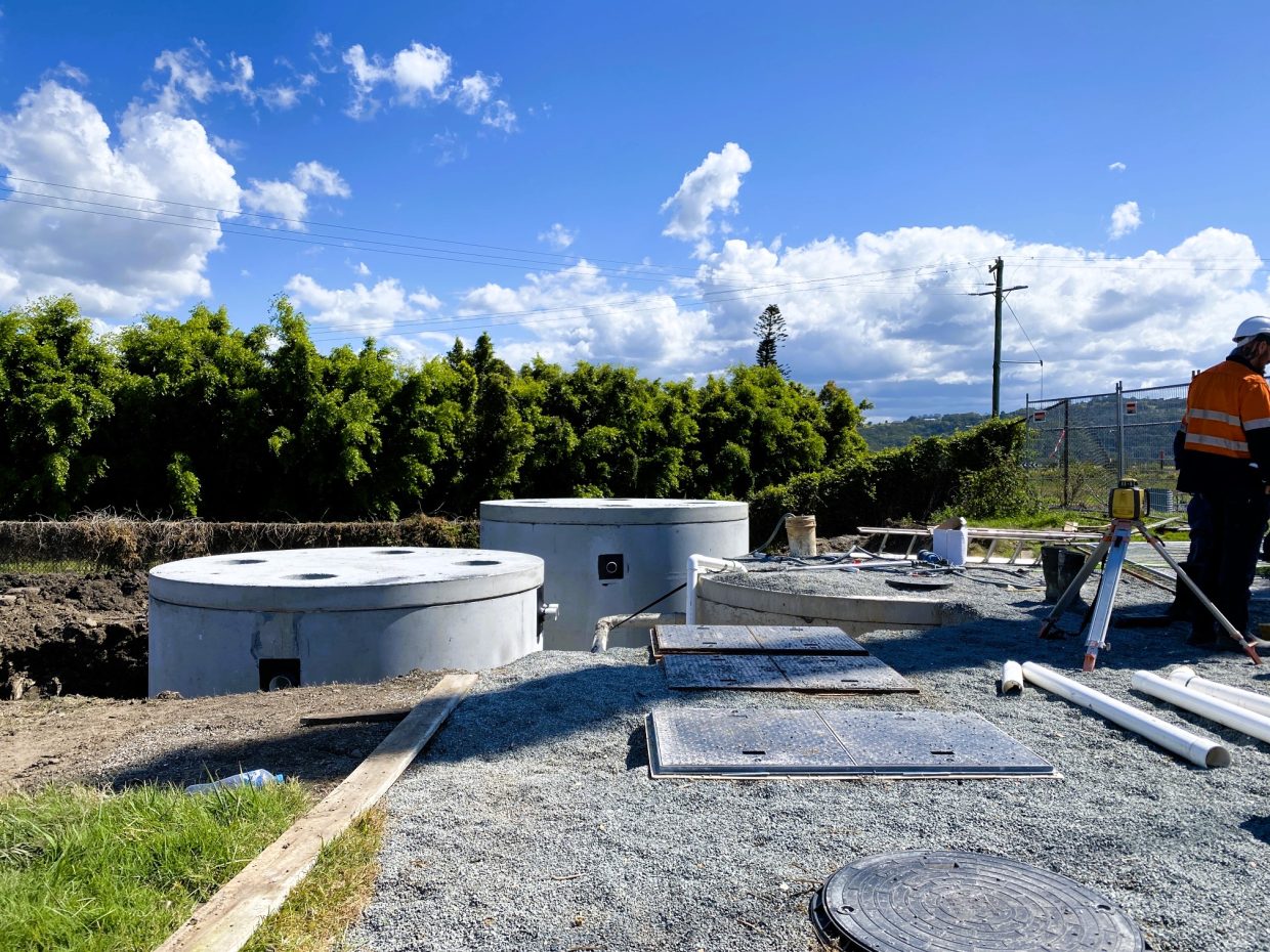 Worker next to a cement tank, highlighting the equipment used in construction process.