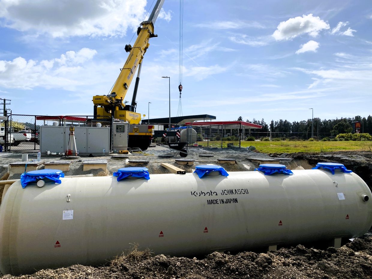 Wastewater infrastructrure positioned at a construction site, surrounded by machinery.