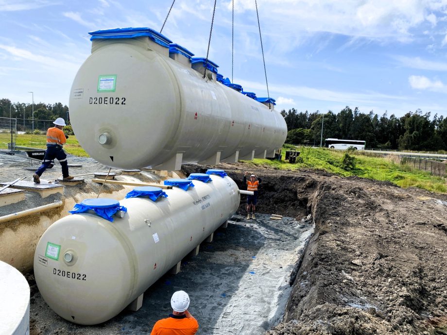Crane hoists a large tank, illustrating the use of heavy-duty vehicles in transporting large equipment.