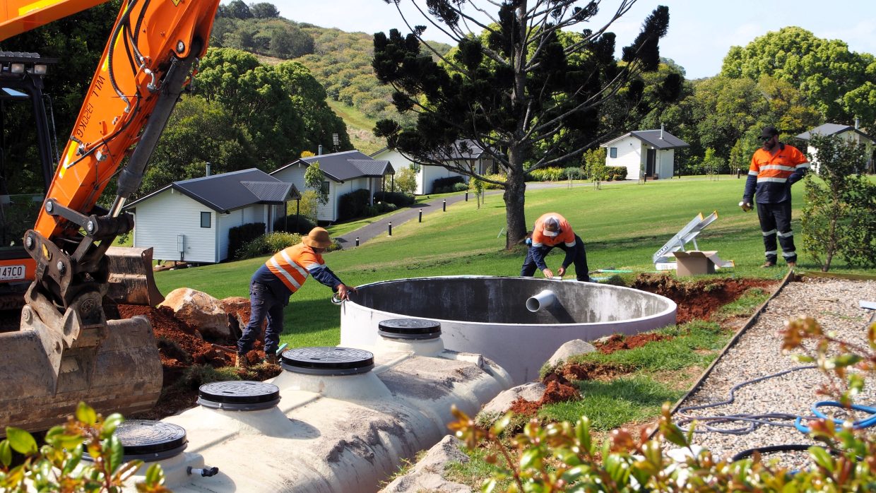 A group of professionals is focused on constructing a large wastewater tank.