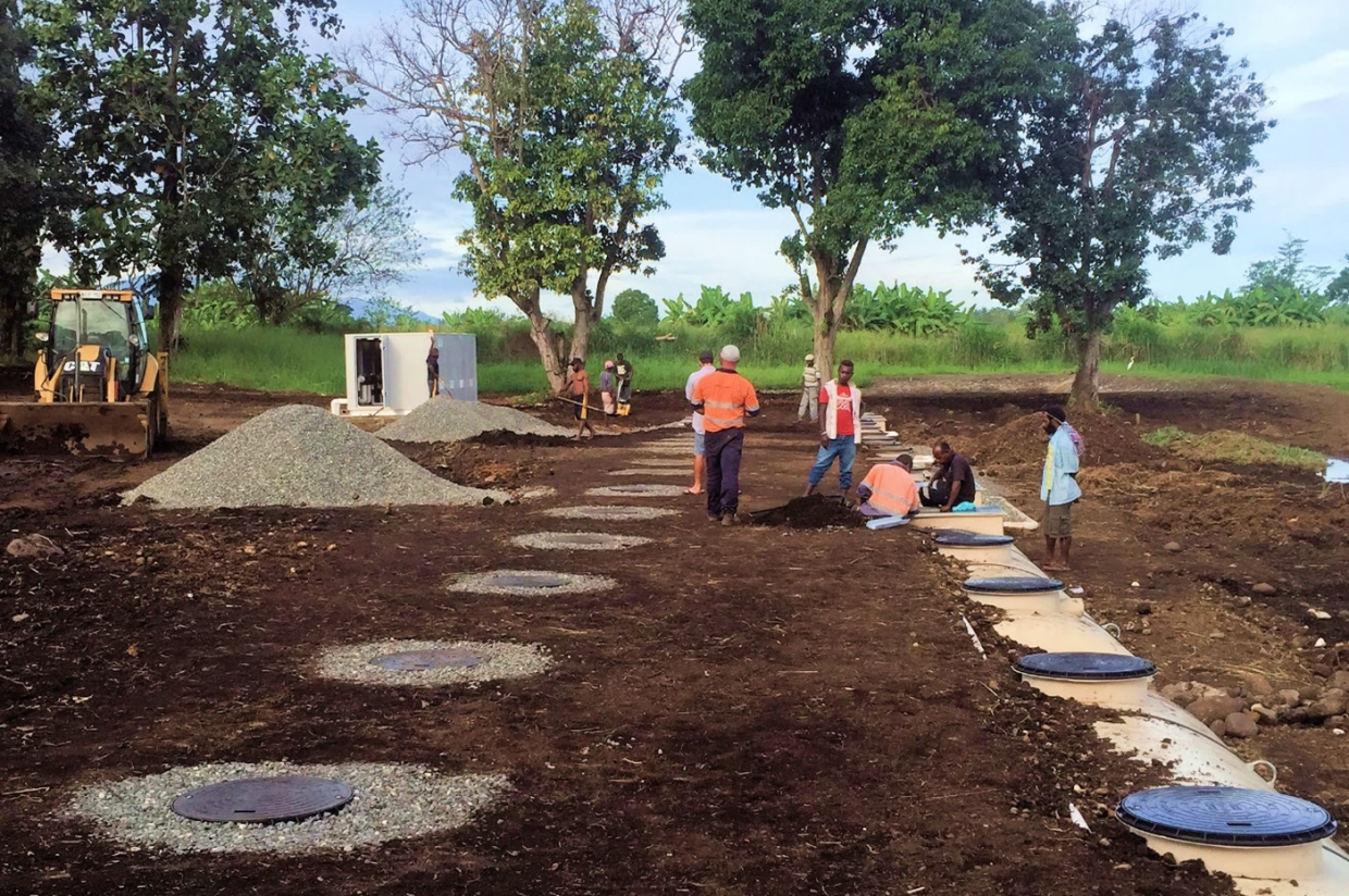 Backfill of the system being completed with a gravel bed for adequate drainage around the inspection lids.